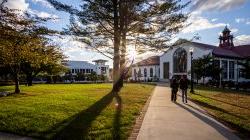 Students walking in front of Cole Hall at sunset